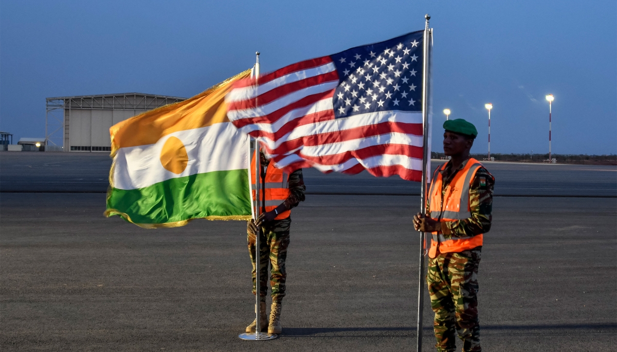 Two Nigerien soldiers hold the American and Nigerien flags at Air Base 101 in Niamey in June 2024.
