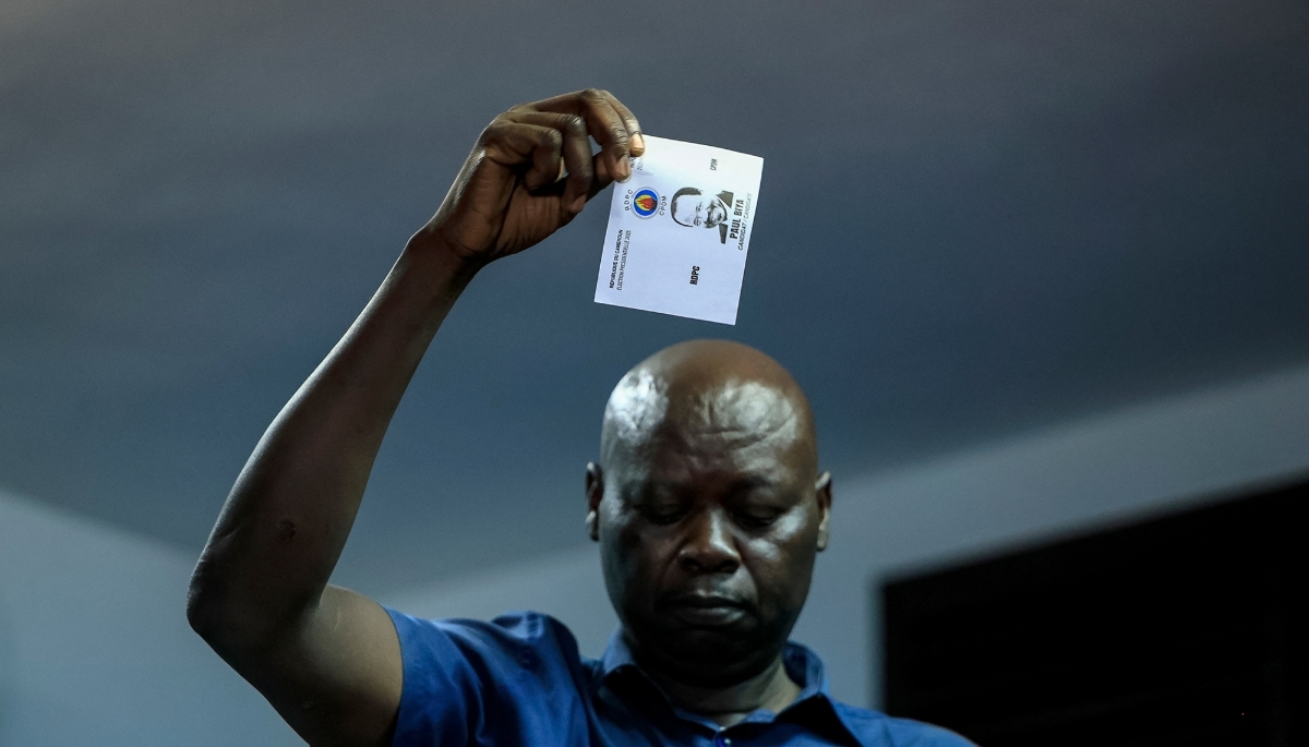 A member of ELECAM holds a ballot for Paul Biya, while votes are counted at a polling station in Yaounde, on 12 October 2025.