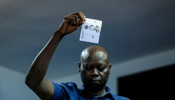 A member of ELECAM holds a ballot for Paul Biya, while votes are counted at a polling station in Yaounde, on 12 October 2025.