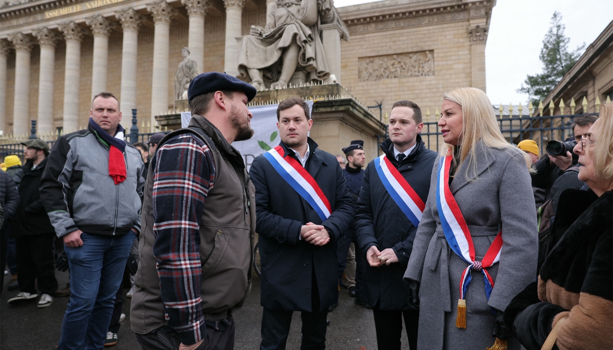 Rassemblement National MP Hélène Laporte (2R) speaks with farmers in front of the French National Assembly in Paris on 8 January 2026.