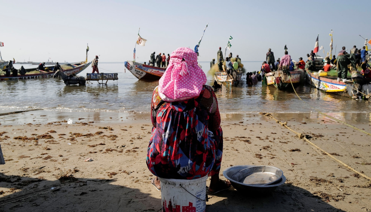 A fish seller waits to buy fresh products from fishermen at the port in Joal, Senegal in 2020.