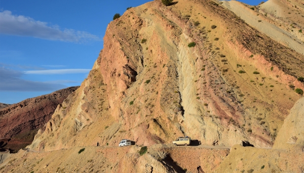 Vehicles navigate their way along a narrow road leading to the village of Tighza, Morocco.