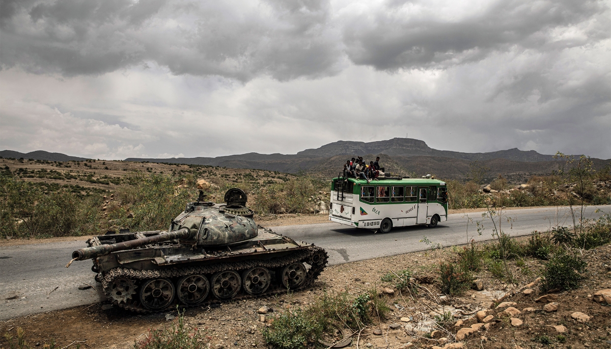 A bus carrying civilians passes a destroyed tank outside Mekele in Ethiopia's Tigray region, in June 2021. 