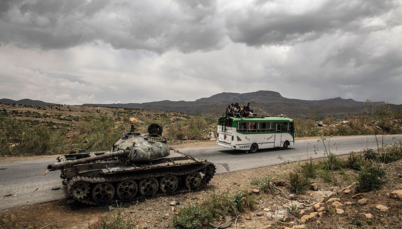 A bus carrying civilians passes a destroyed tank outside Mekele in Ethiopia's Tigray region, in June 2021.