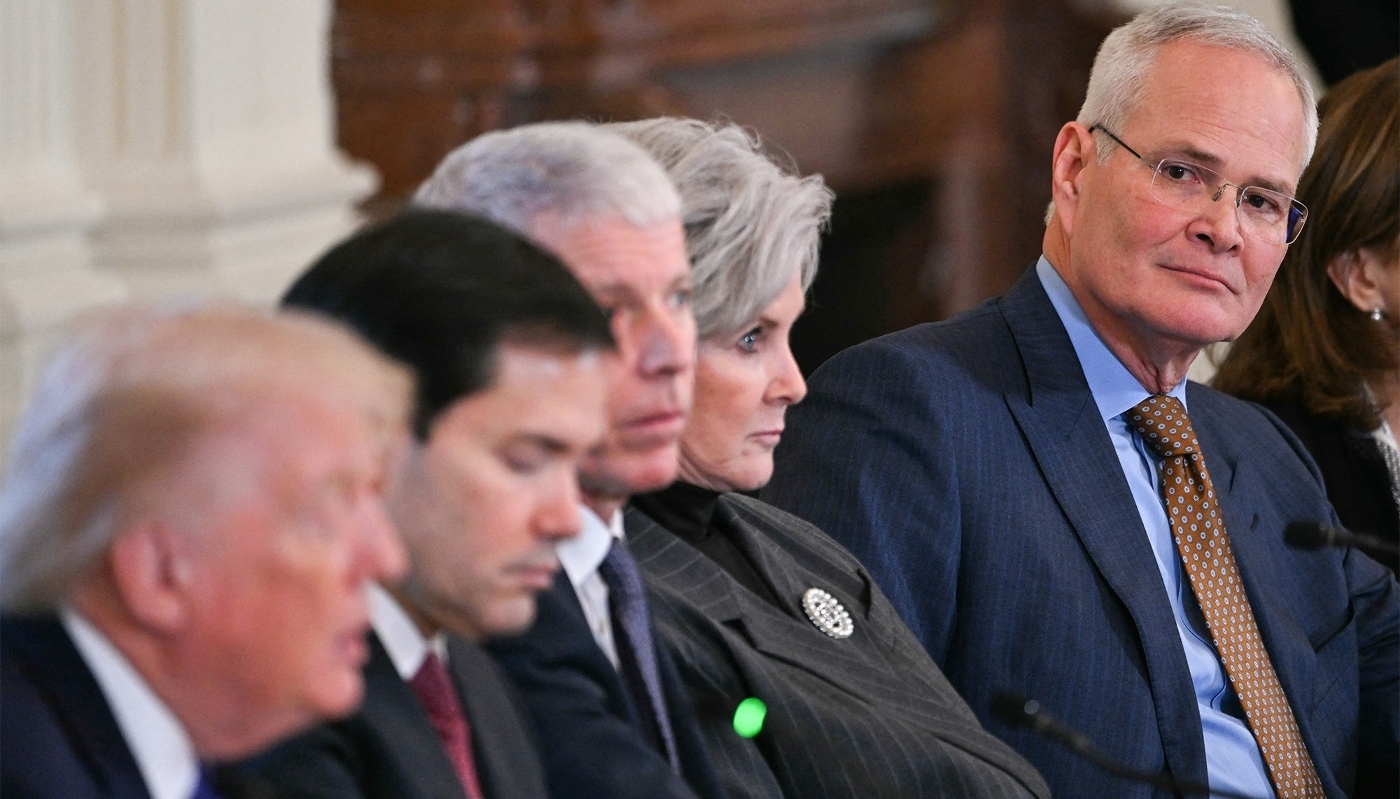 ExxonMobil CEO Darren Woods (right) listens to US President Donald Trump speak in Washington on 9 January 2026.