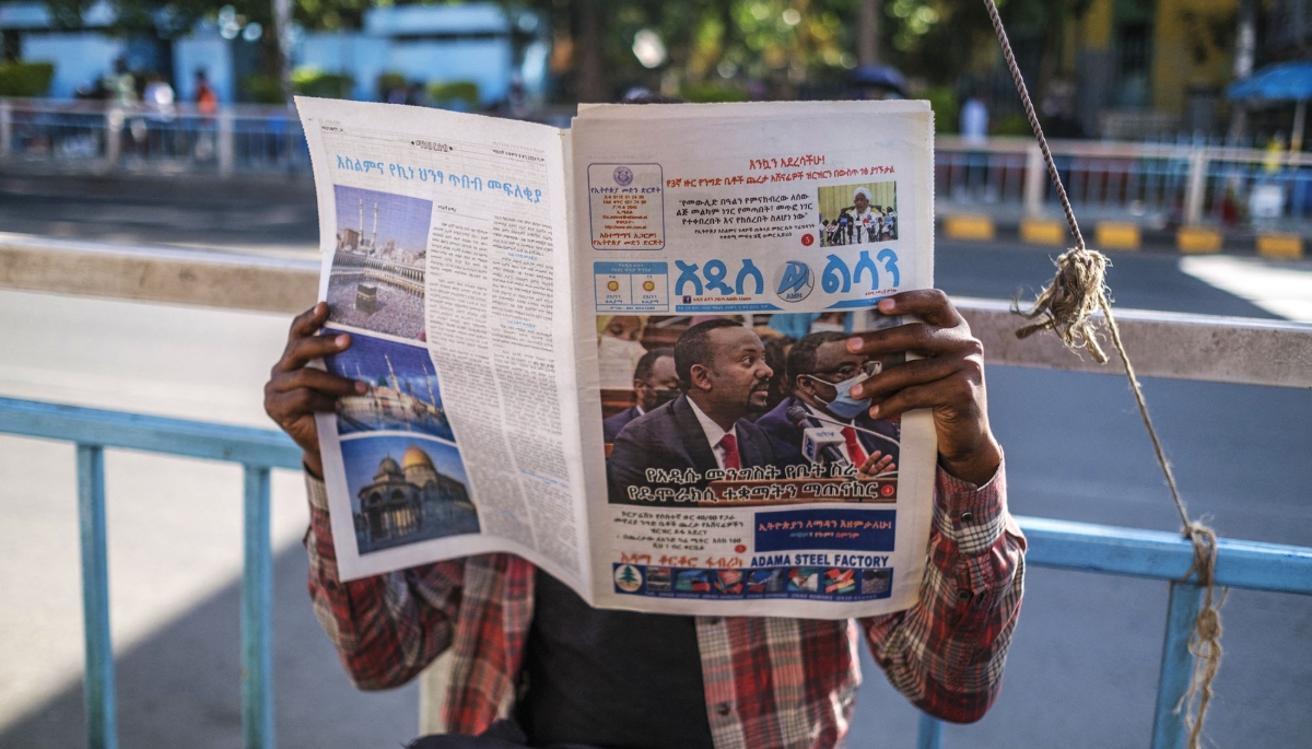 A man reading the newspaper in downtown Addis Ababa, on 3 November 2021,  Prime Minister Abiy Ahmed on the front page.
