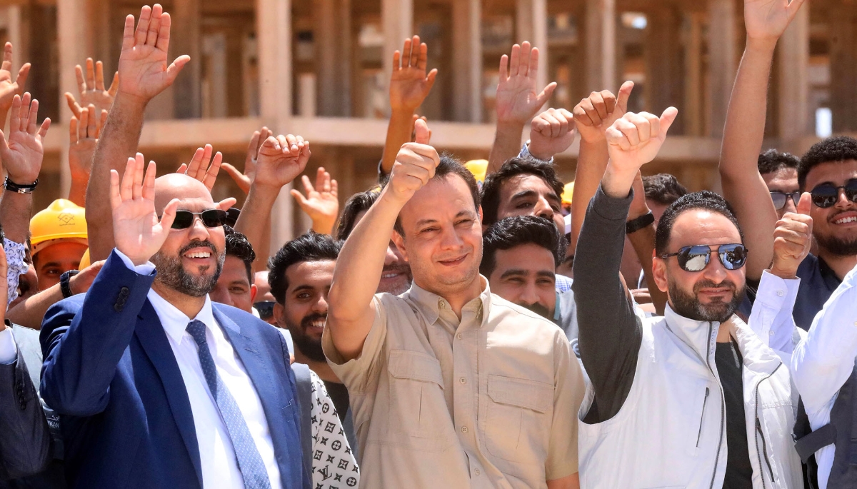 Belkacem Haftar (centre), head of the Reconstruction of Libya Fund, with his team at a 20,000-home building project, Benghazi, on 18 May 2025.