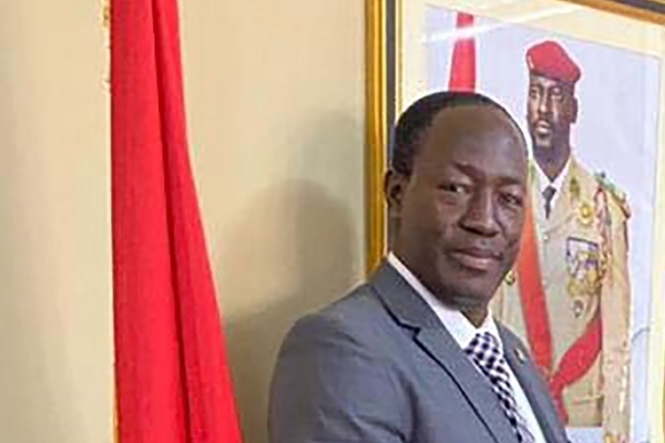 Guinea's Minister of Mines Moussa Magassouba in front of a portrait of President Mamadi Doumbouya.